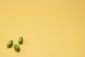マイクロきゅうりを数粒左下に配置した黄色系背景あり俯瞰撮影