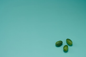 マイクロきゅうりを数粒右下に配置した緑色系背景あり俯瞰撮影