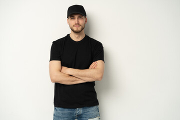 Portrait of happy casual man smiling, guy wearing black t-shirt an d cap at white wall, Isolated on...