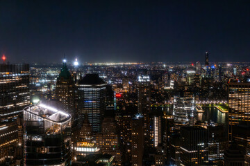 Fototapeta na wymiar New York City Aerial Night Cityscape with Stunning Manhattan Landmarks, Skyscrapers and Residential Buildings. Wide Angle Panoramic Helicopter View of a Popular Travel Destination