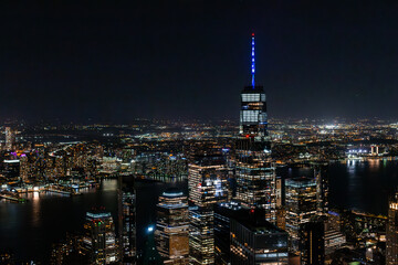Night Aerial Shot of the One World Trade Center Skyscraper with Antenna. Helicopter Photo of a Group of Glass Buildings in Manhattan