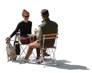 Backlit photo of a man and a woman with a dog sitting in a street café and talking, isolated on...