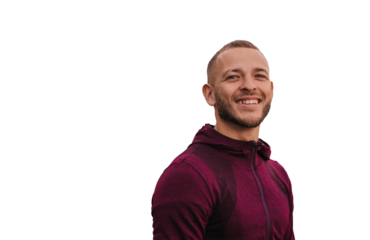 Cheerful young man in sportswear standing against transparent background at broad smiles satisfied by training, jogging. Male runner at exercise. Sport, fitness, health.