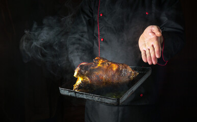 Cooking duck in the oven on a baking sheet. The chef introduces roasted hot poultry for a delicious...