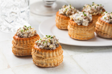 White table with creamy Chicken and Mushroom Vol Au Vent. Appetizer for the festive season, mini...