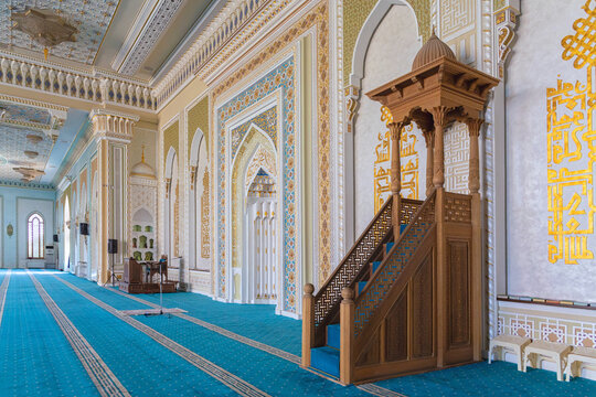 Wooden minbar in the interior of Hazrati Imam mosque. Painted mihrab at background. Copy space. April 06, 2023. Tashkent, Uzbekistan