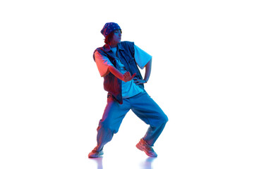Dynamic image of young girl in casual sportive cloths dancing hip hop isolated over white background in neon light. Concept of contemporary dance, street style, youth, hobby, action, lifestyle