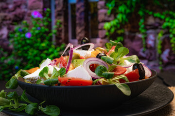 Greek salad in a beautiful dish, unusual background, mid-earth seafood cuisine. Homemade food, Restaurant food.