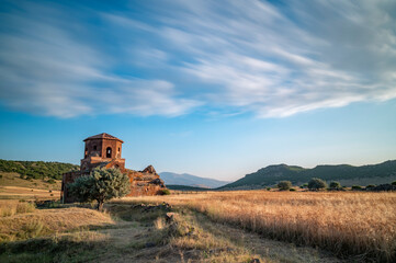 Fototapeta na wymiar Red church ruins in Nigde province, sunset colors and clouds in the sky