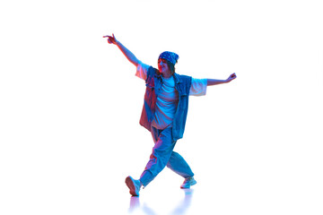 Sportive young woman in casual jeans sportive clothe dancing modern dance isolated over white background in neon light. Concept of contemporary dance, street style, youth, hobby, action, lifestyle