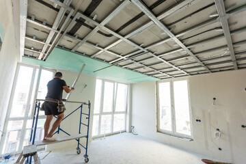Drywall Installers. Men holding a gypsum board figured cut