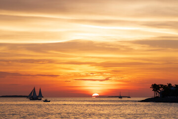 A spectacular sunset, off the coast of Key West, Florida, with sailing boats silhoutted against the orange sky © parkerspics