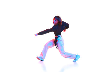 Young woman dancing hip hop, breakdance, dance hall isolated over white background in neon light. Concept of contemporary dance, street style, youth, hobby, action, lifestyle