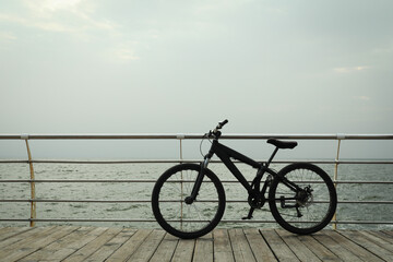 Fototapeta premium Bicycle on wooden boardwalk outdoors, space for text