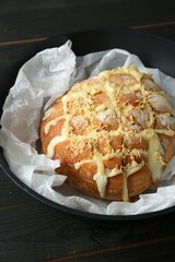 Freshly baked bread with tofu cheese and lemon zest on black wooden table