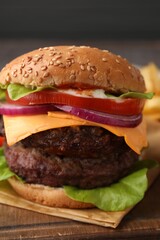 Tasty cheeseburger with patties on wooden board, closeup