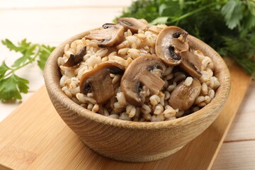 Delicious pearl barley with mushrooms on table, closeup