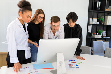 Communication of four different-race colleagues in the office.