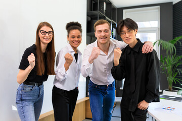 A happy multinational team rejoices at the successful start of business in the office.