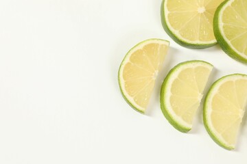Lime pieces on white background, above view. Space for text