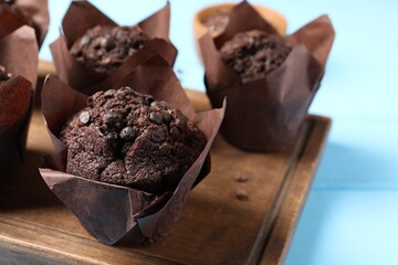 Tasty chocolate muffins on light blue table, closeup