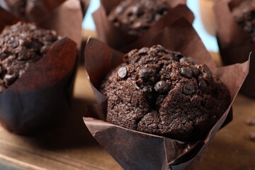 Tasty chocolate muffins on wooden board, closeup