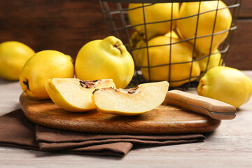 Naklejka na ściany i meble Ripe whole and cut quinces with knife on wooden table, closeup