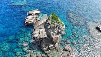 Sacred rock island with lion-shaped appearance in beautiful blue sea of Okinawa