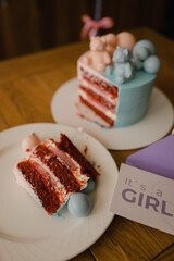 beautiful delicious cake in blue and pink colors especially for a gender party, cream cake with jam and balloons, who is a boy or a girl inside? Bears on a birthday cake