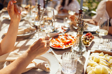 Closeup of female hands holding glasses of champagne. Making a celebratory toast with sparkling...