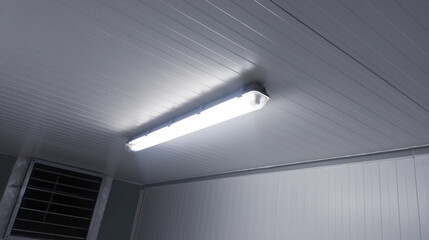 Close-up of a installation a long LED light bulb on the ceiling corridor room.