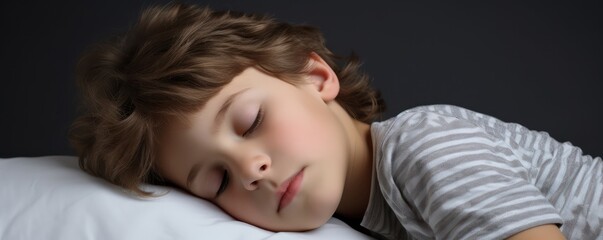 Fototapeta na wymiar adorable essence of a young boy child as he sleeps on a white pillow, isolated against a gentle grey background, showcasing the beauty of innocent rest.
