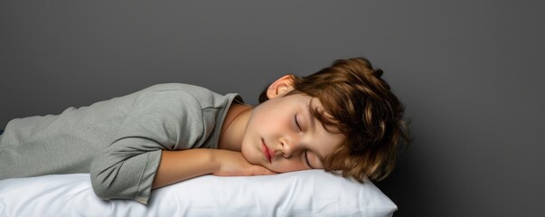Obraz na płótnie Canvas studio photo where a sweet young boy child is nestled in a peaceful sleep on a white pillow