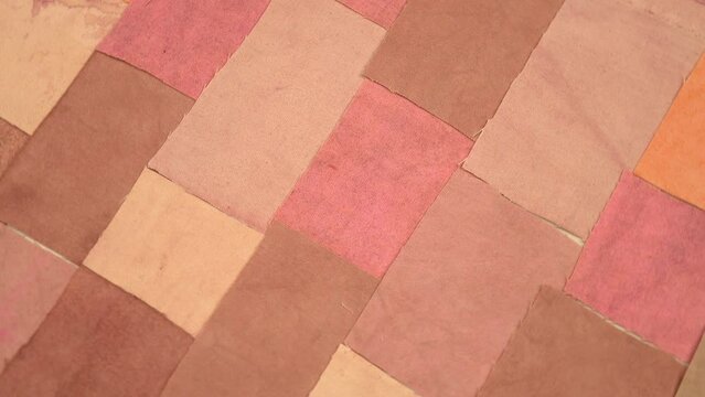 Handmade background in patchwork style with cotton fabric elements in pink and brown tones, background