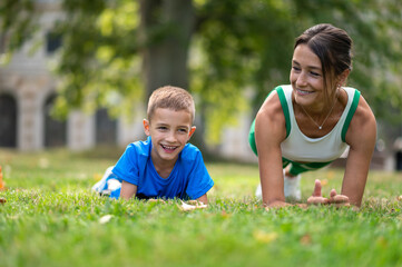 Fototapeta premium Fit woman and her son exercising in the park