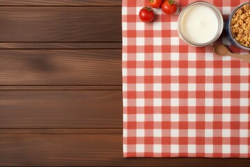 A food background with a glass bowl of cereal breakfast, milk or yogurt bottle and striped table cloth. Wooden background, top view