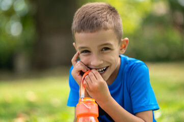 Fototapeta premium Cute boy of school age in blue tshirt looking contented