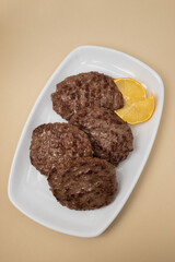 fried cutlet for burger with lemon. In a white plate