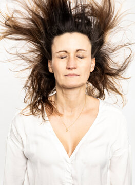 Studio Portrait Frau mit geschlossenen Augen und fliegenden Haaren