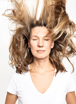 Studio Portrait Frau mit geschlossenen Augen und fliegenden Haaren