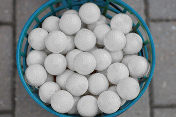 Lots of white golf balls in a bucket. Preparation for the tournament among professionals.
