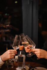 Cheers. People celebrate and raise glasses of sparkling wine for toast. Group of man and woman cheering with champagne. Friends are drinking at a party. Сloseup drink in a glass.