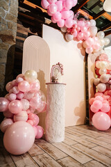 Arch decorated with pink, brown balloons. Photo wall decoration space or place for text. Cake is...
