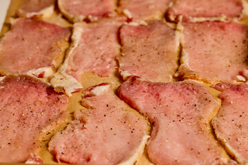 Pork tenderloin thinly sliced and prepared for schnitzel before cooking.
