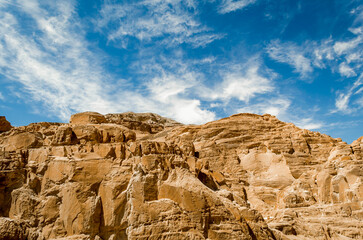 high rocky mountains in the desert against the blue sky and white clouds in Egypt Dahab South Sinai