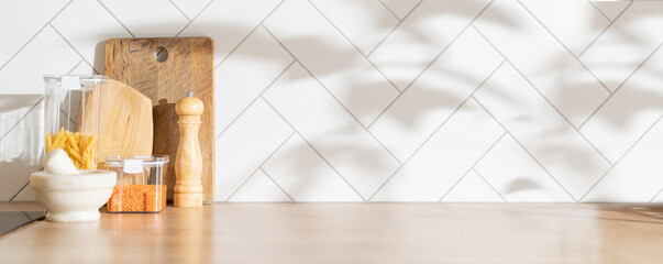 Kitchen background with cutting board, utencils, groceries, direct sunlight, shadows from trees