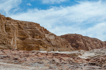 Fototapeta premium ruins of houses in the desert against the backdrop of high rocky mountains and blue sky with white clouds in Egypt Dahab South Sinai