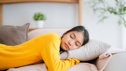 Asian woman resting at home on couch, feeling exhausted after work, lacking energy, or overworked,...