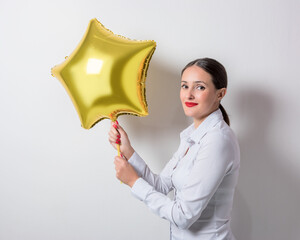 Young pretty woman holding a star shaped balloon. Holiday concept.