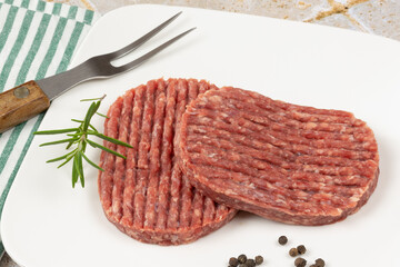 steaks hachés cru dans une assiette	